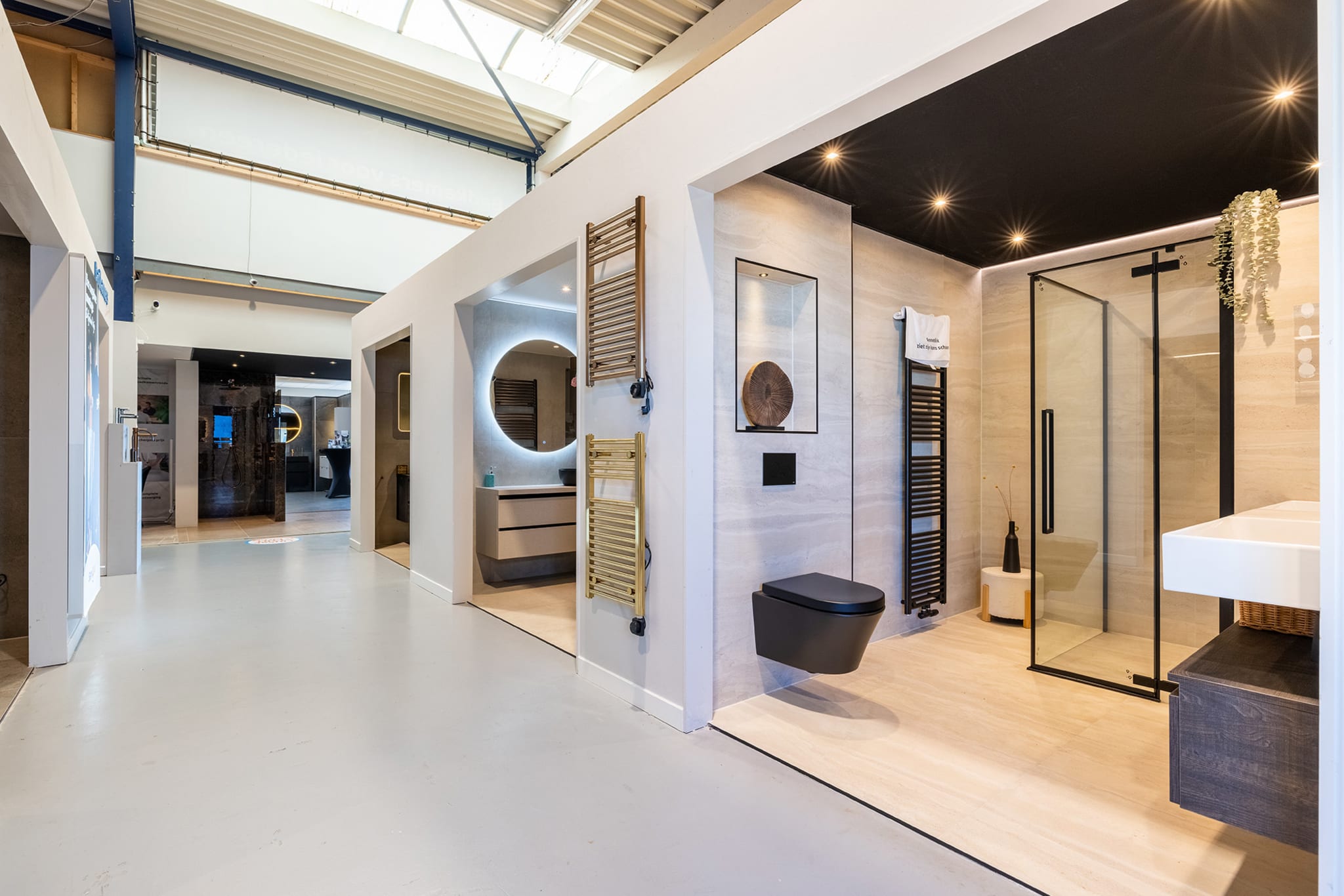 Badkameropstellingen met inloopdouche, zwart hangtoilet en verlichte spiegel in de winkel van Sani4All Zwolle