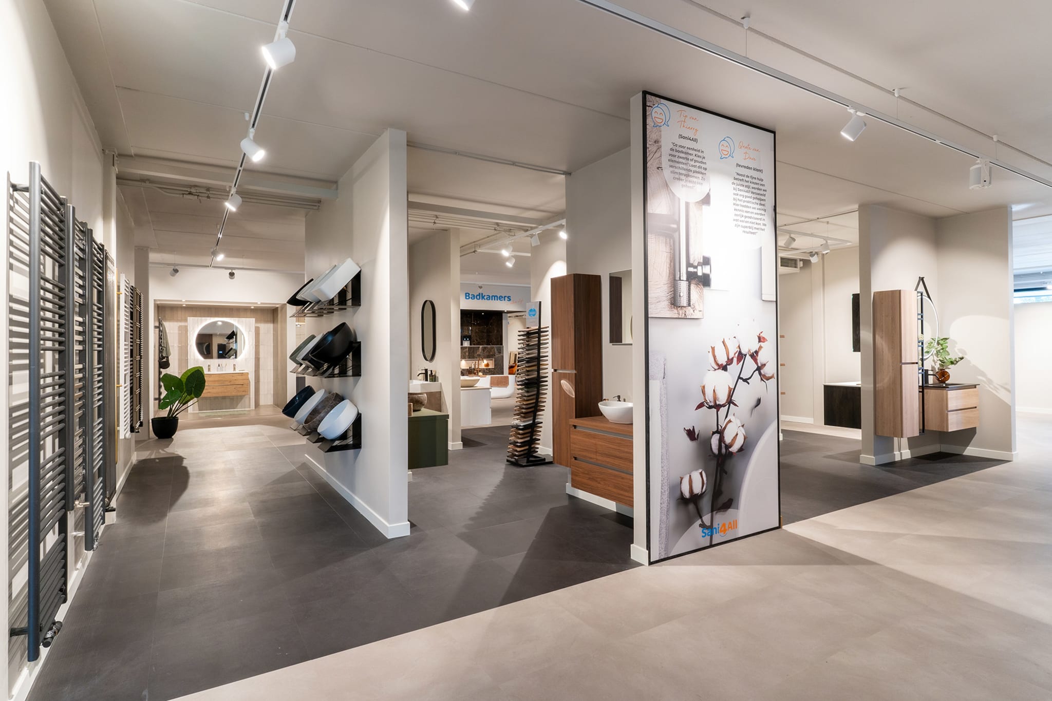 Overzicht van de Sani4All winkel met diverse badkameropstellingen en inspiratieborden.