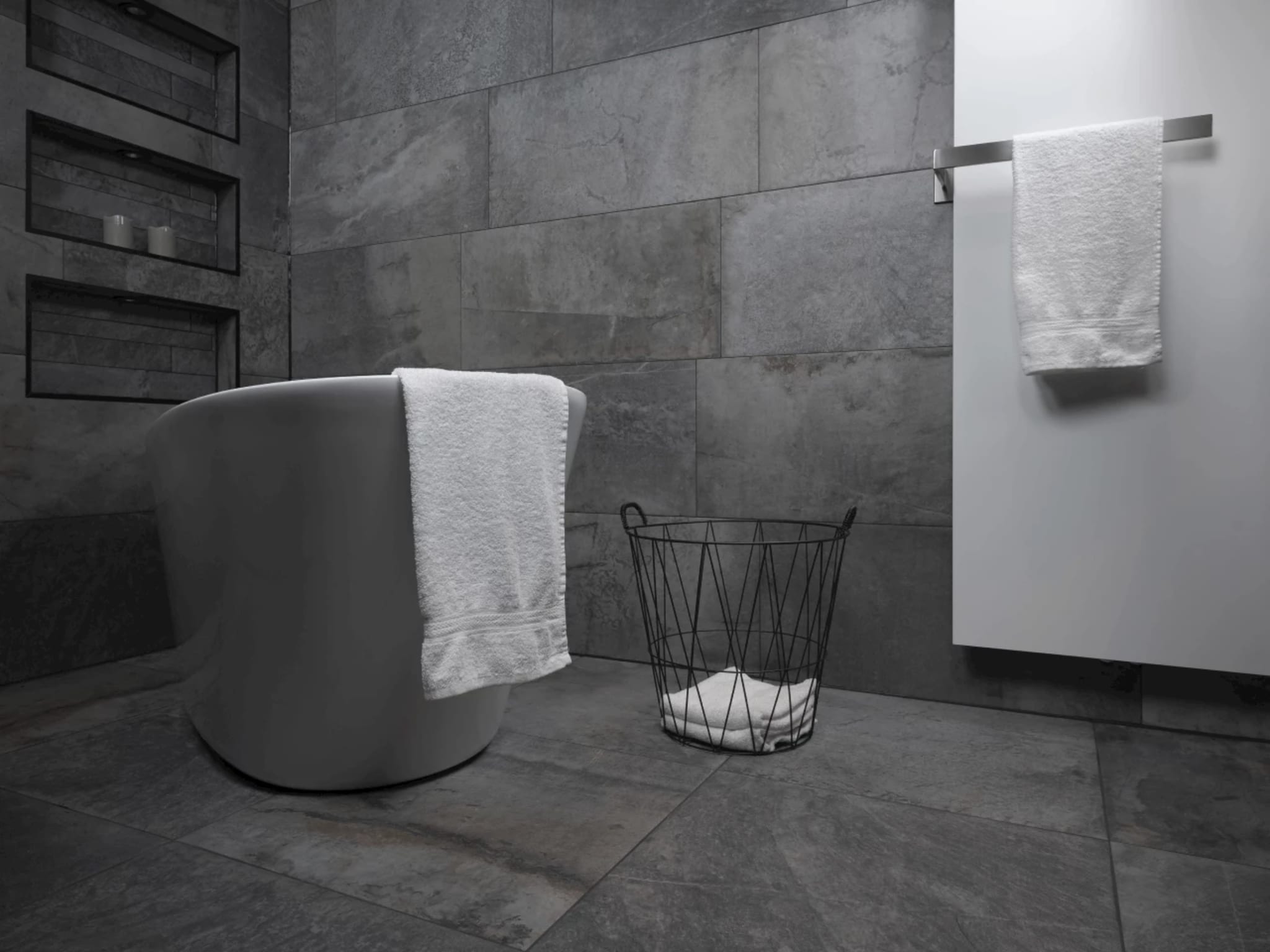 Witte designradiator met handdoekhouder naast het vrijstaande ligbad