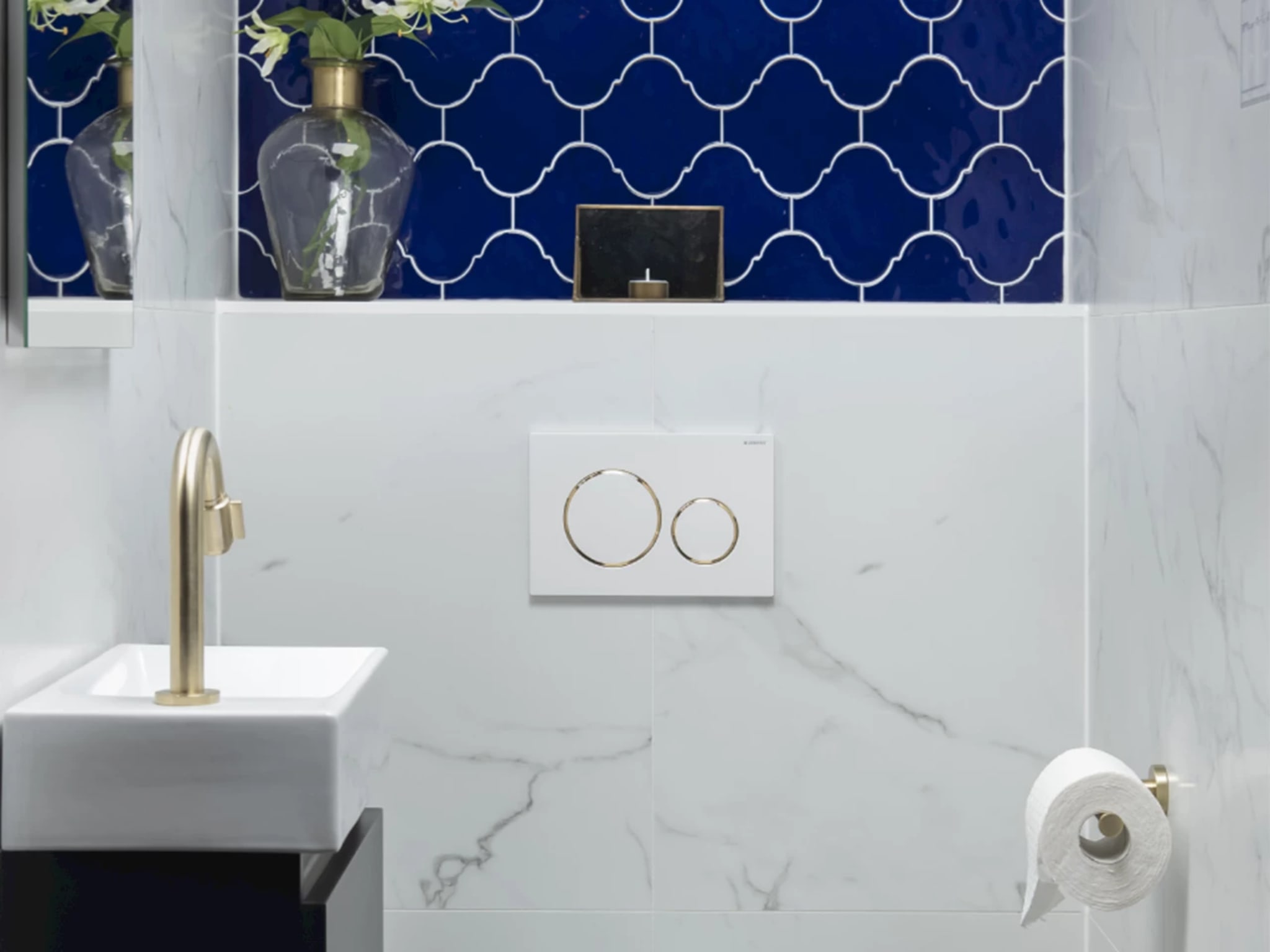 Compleet toilet Arabesque Blue met een kobaltblauwe wand van lantaarnvormige tegels boven lichte marmerlook tegels