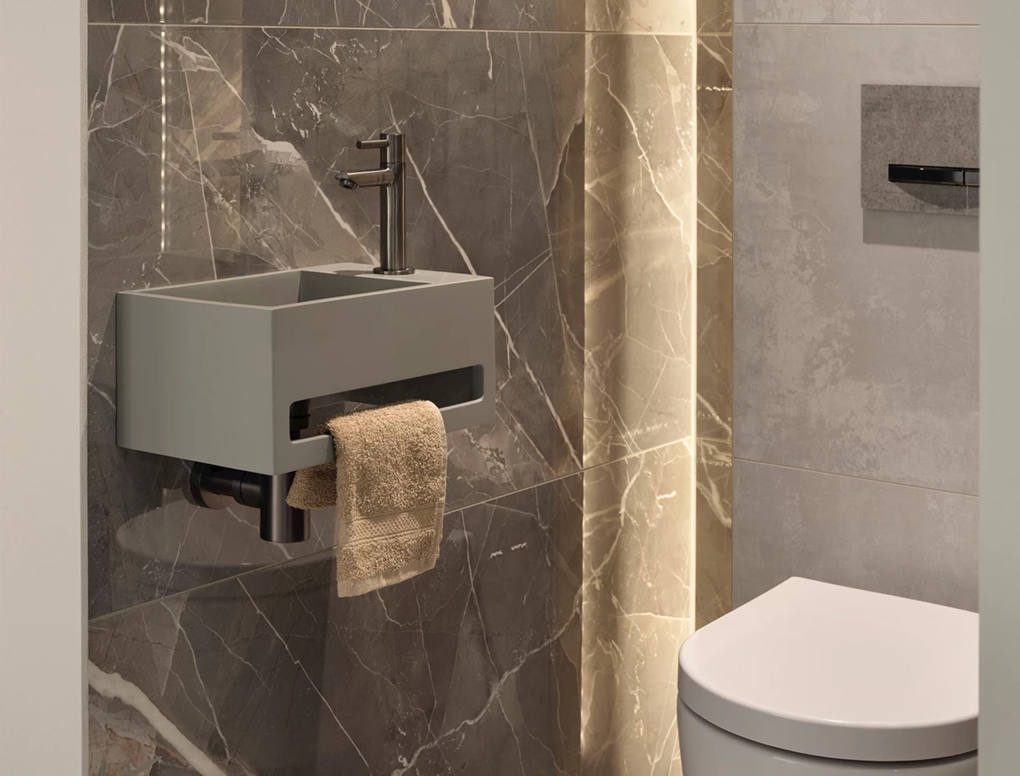 Compacte grijze fontein aan de wand met een hoge kraan in Gun Metal en een handdoek door de sleuf eronder