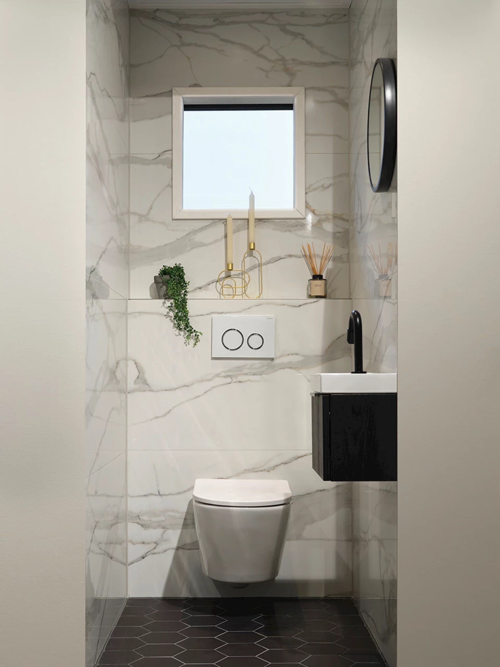 Compleet toilet Marble Hexagon met lichte marmerlook wandtegels, zwarte hexagontegels op de vloer en een zwarte fonteinkast