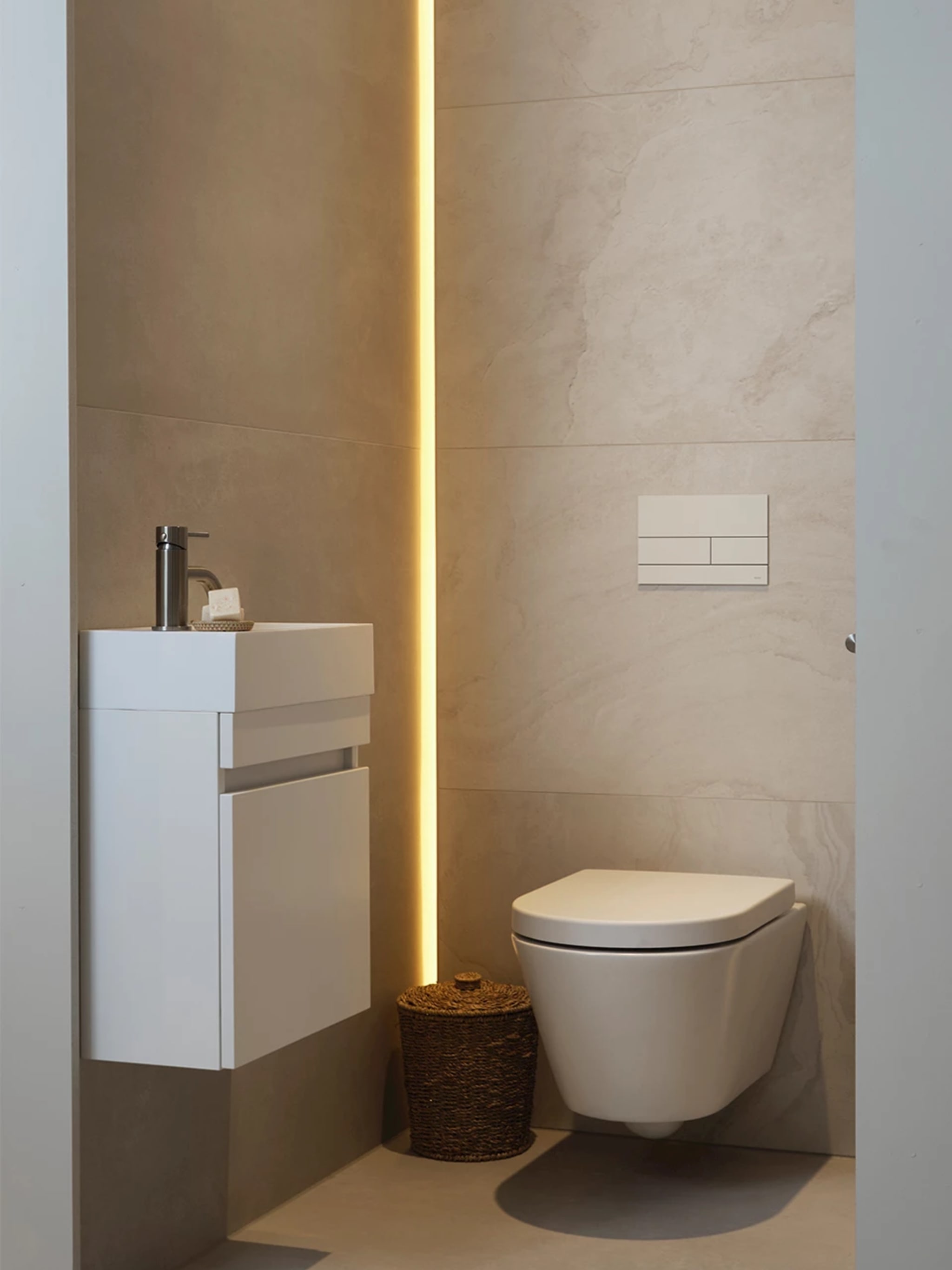 Compleet toilet Marble XL met grote zandkleurige tegels, een mat wit wandcloset en links een mat witte fonteinkast