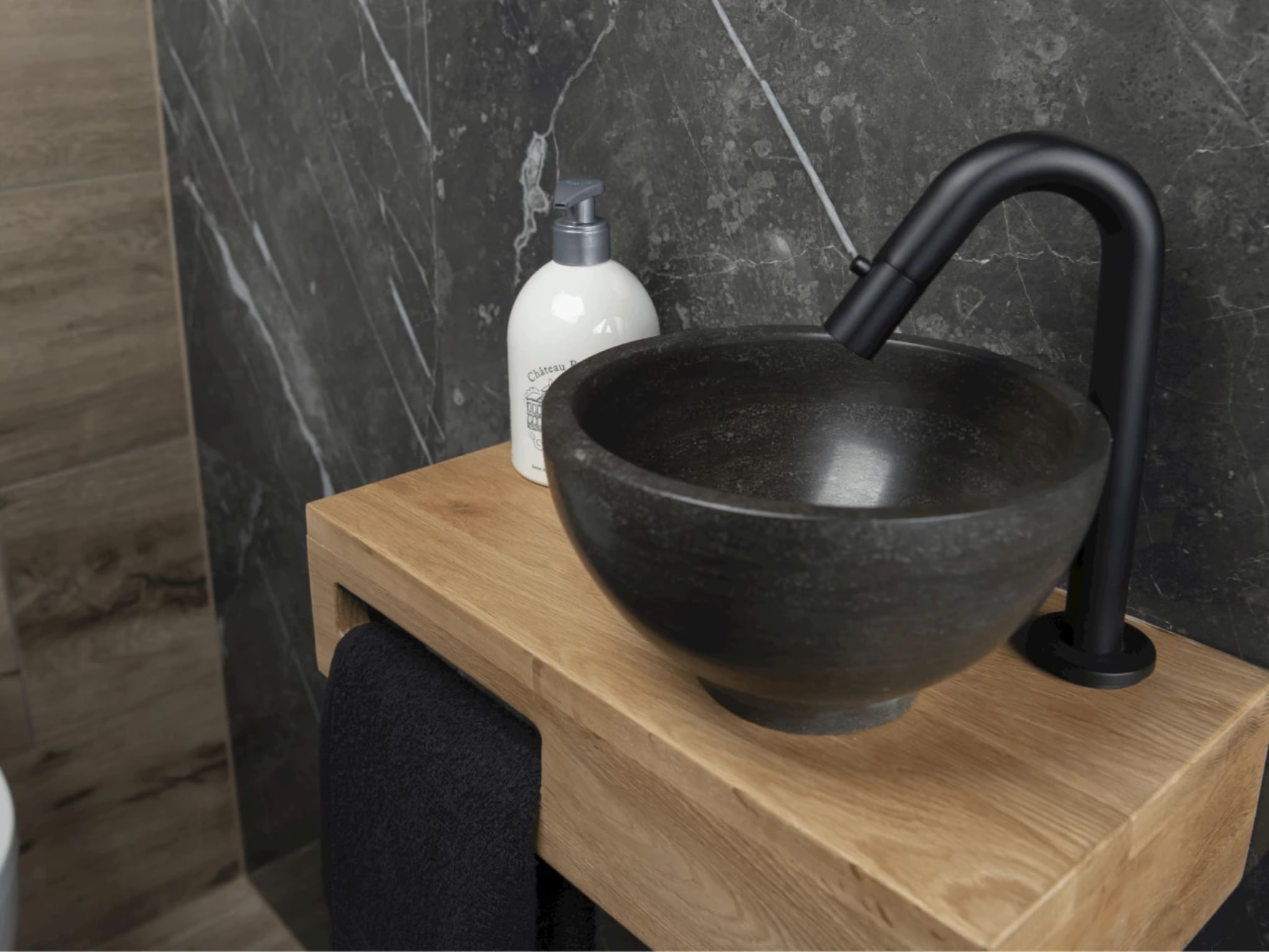 Zwarte natuurstenen waskom met mat zwarte kraan op houten fonteinplank in toilet Modern Times