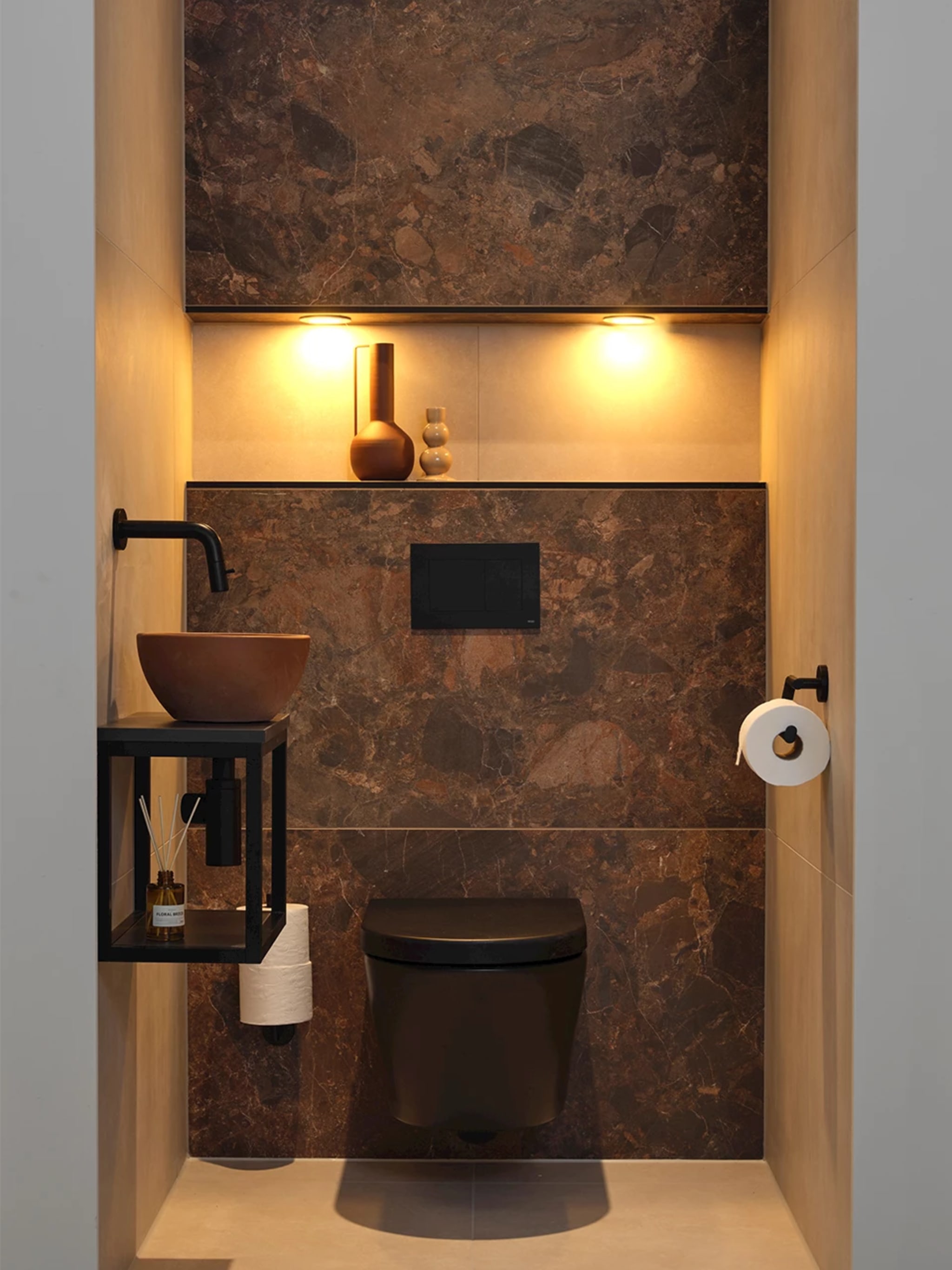 Compleet toilet Terra Mud Run met terracottakleurige wandtegels, een mat zwart wandcloset en een verlichte nis