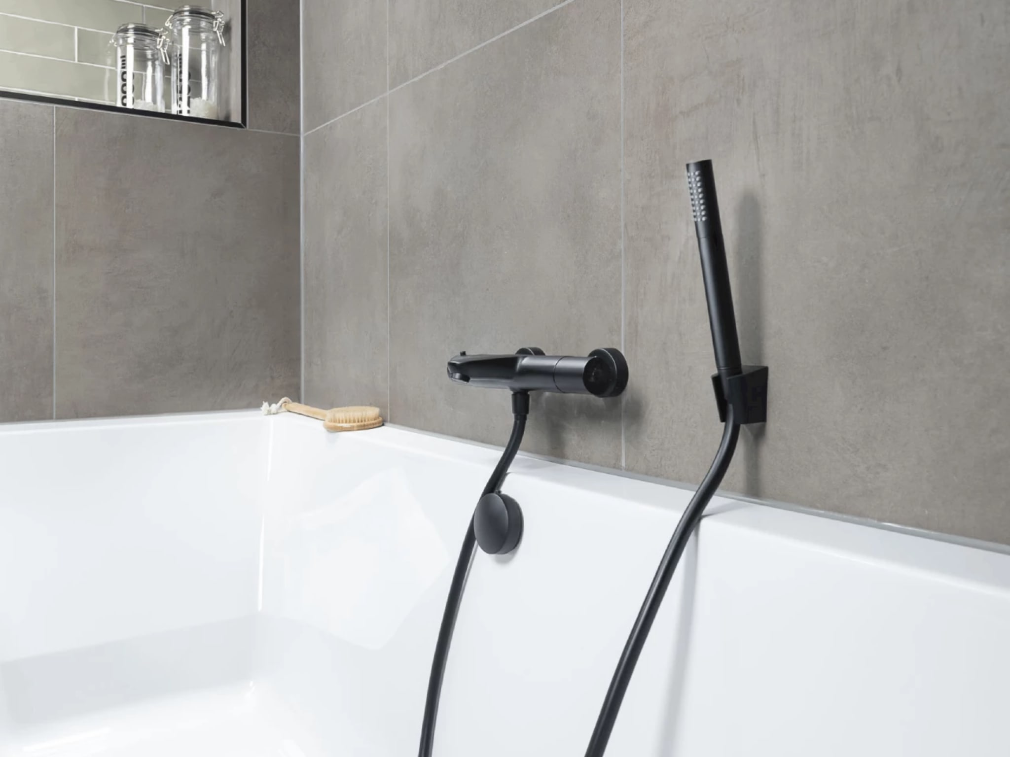 Mat zwarte badkraan met handdouche op het inbouwbad van badkamer Spring Time