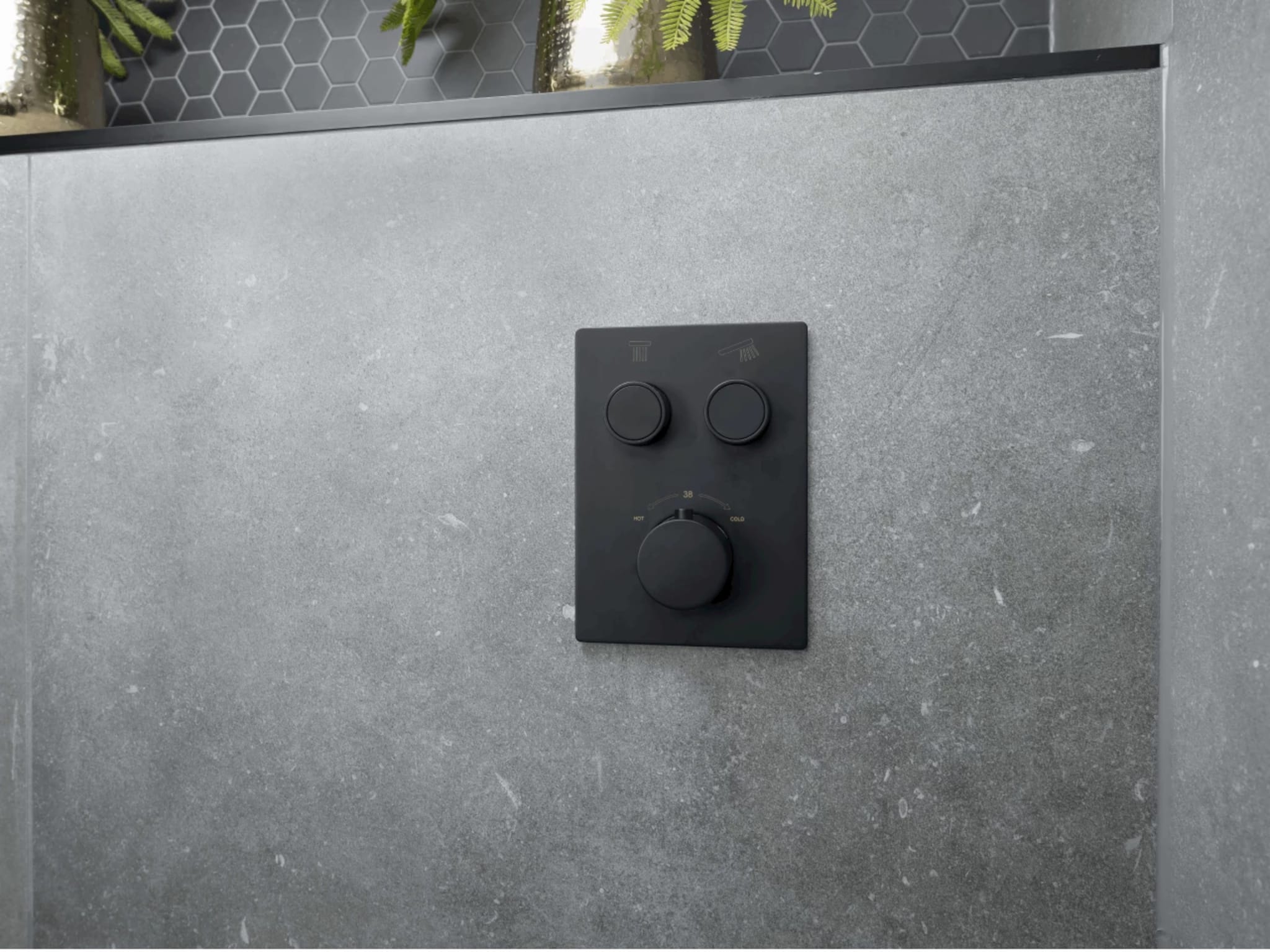 Mat zwarte smartcontrol thermostaatkraan op grijze betonlook wandtegels met hexagon decortegels in de douchenis