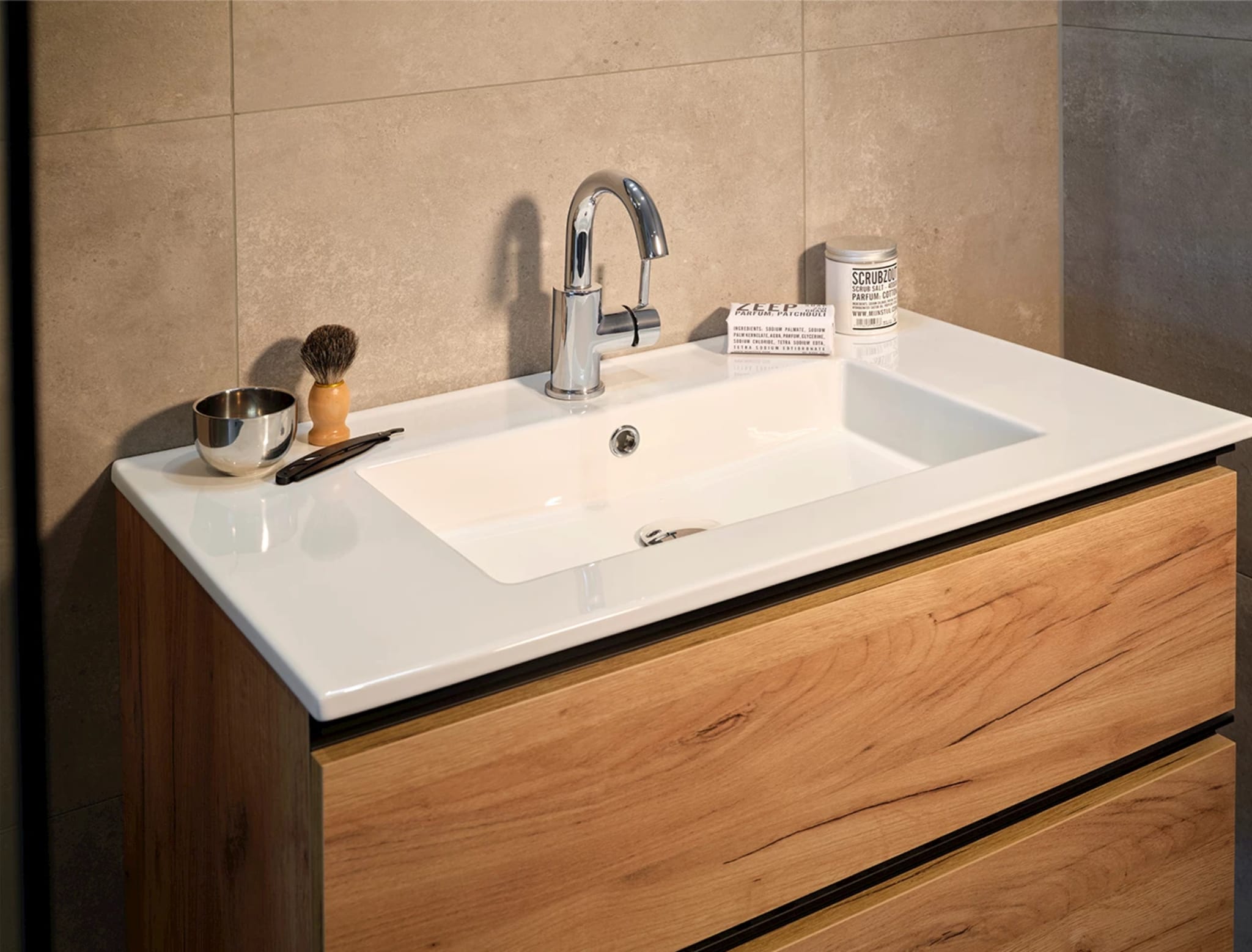 Wandhangend eikenlook badmeubel met een keramische wastafel met brede aflegrand