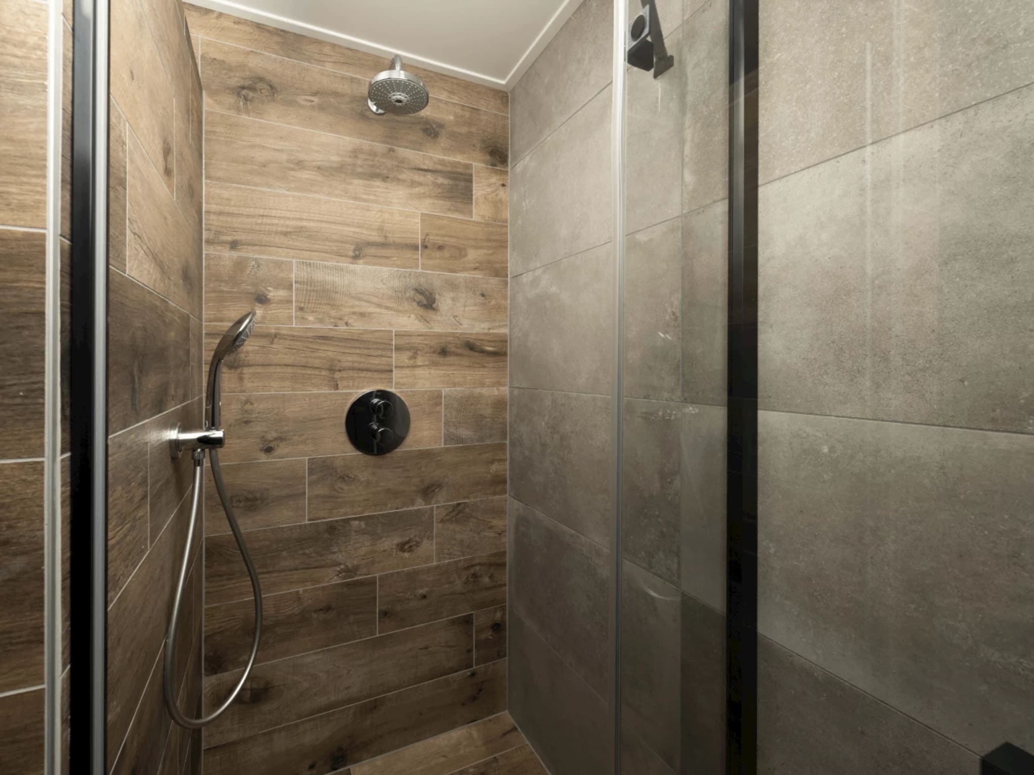 Douche met chromen regendouche, handdouche en inbouw thermostaatkraan op houtlook wandtegels