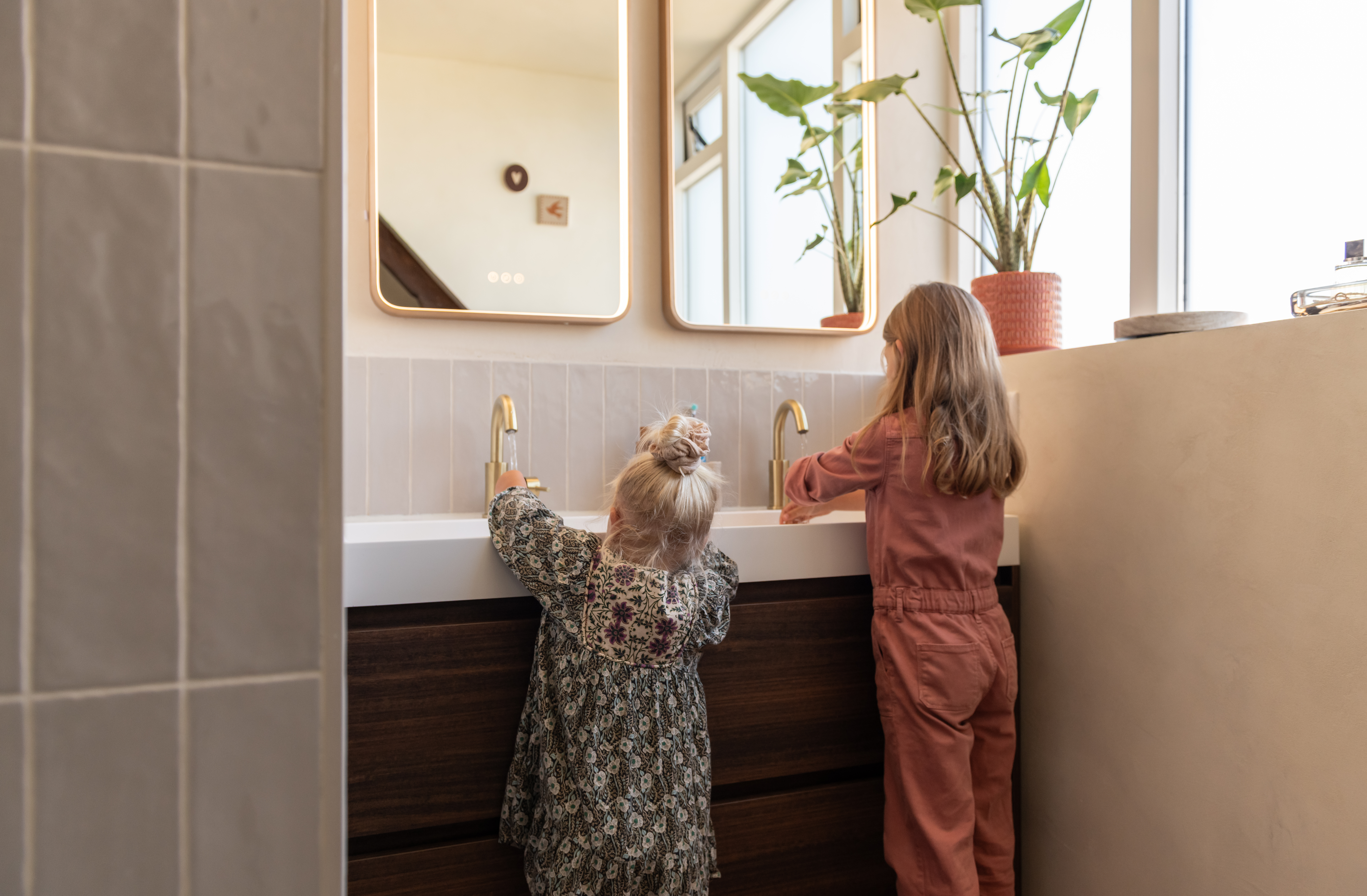 Een lichte badkamer met messing details bij familie Mussche
